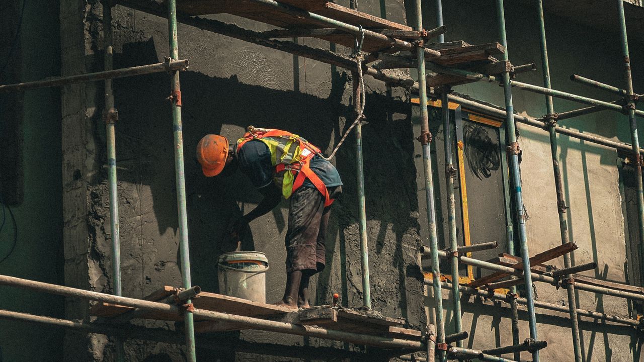 services-02 A construction worker applies plaster on a building facade in Abuja, Nigeria.