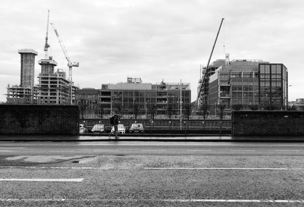 Black and white photo of a construction site with cranes and buildings under development.